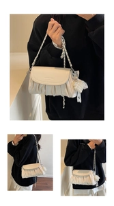 Detail of cream white pleated cloud bag with gold chain and pearl grape charm
