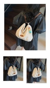 Detail view of cream canvas tote bag with brown leather straps and cute clown pendant accessory
