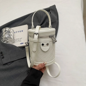 Detailansicht einer weißen gesteppten Zylindertasche mit silbernen Nieten und Markenlogo