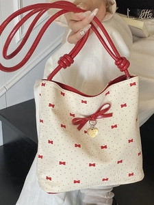 Chic off-white underarm bucket bag with red bow prints and heart metal charm