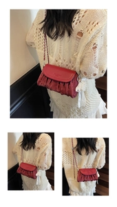Close-up of vintage red pleated soft leather crossbody bag with silver chain strap