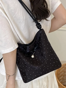 Fashionable black polka dot bucket bag with bow tie strap and elegant pearl pendant