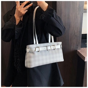 Detailed texture of grey plaid underarm bag with decorative white leather strap and buckle