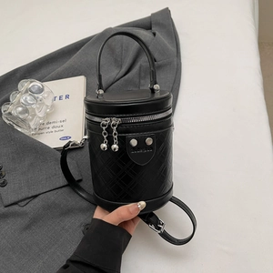 Detailaufnahme der schwarzen Steppleder-Beuteltasche mit Silberreißverschluss und Perlenkette