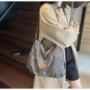 Detail of vintage gray canvas tote with brown leather strap and brand logo patch