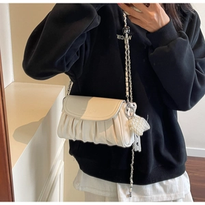 Detailed view of the white cloud bag texture with silver chain and pearl ornament