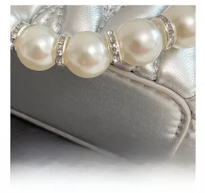 Macro shot of silver quilted leather bag showing fine stitching and pearl handle detail