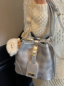 Silver-grey checkered bucket bag with plush sheep charm and gold metal buckle detail