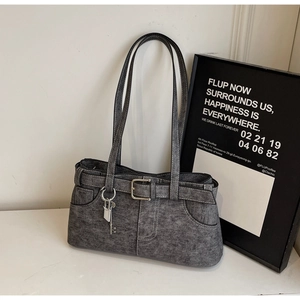 Close-up of grey denim texture tote bag with metal key charm and buckle details