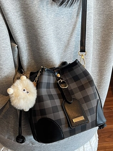 Fashionable black and grey plaid bucket crossbody bag with cute white fur ball charm for women