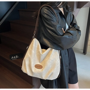 Detail of beige suede tote bag with brown leather straps and Banatu brand logo