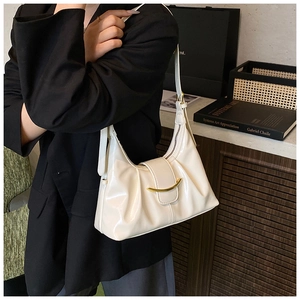 Detail view of cream white pleated underarm bag with gold crescent buckle on shoulder