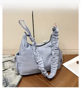 Close-up of light blue pleated hobo bag with drawstring detail and metal zipper