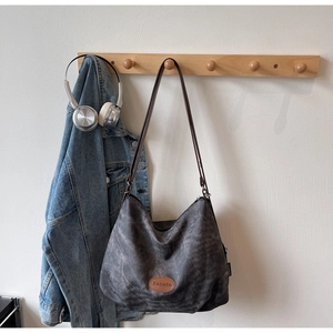 Detailed view of the Banatu logo patch on a vintage dark gray hobo tote bag style