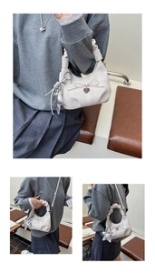 Detail of checkered beige crossbody bag with star pendant and ruched cloud handle