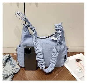 Detail of light blue pleated shoulder bag showing drawstring pocket and size reference
