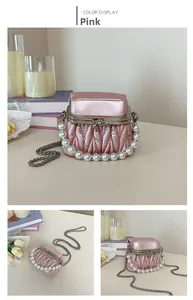 Detailed view of pink pleated handbag with pearl handle and rhinestone embellishments