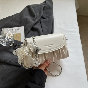 Detail of off-white ruched leather bag with silver chain strap and pearl heart charm