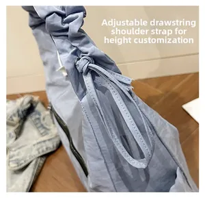 Detail of adjustable drawstring pleated strap on sky blue nylon shoulder bag