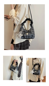Detail of checkered hobo bag showing star pendant and ribbon bow decoration