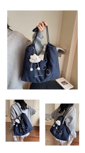 Détail du sac cabas en jean bleu avec broderie ho blanche et breloque nuage en peluche