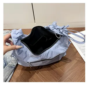 Macro view of light blue pleated tote with spacious black interior and zipper pocket
