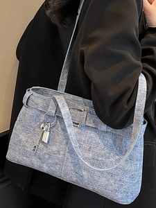 Chic light blue denim texture tote bag with silver key charm and belt strap detail