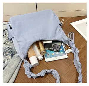 Detail view of sky blue pleated tote bag showing large capacity for tablet and phone