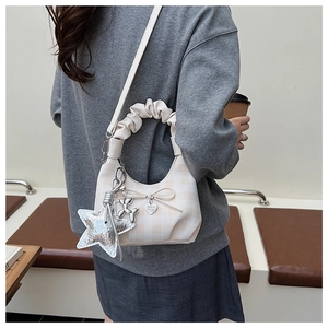 Detail showing checkered patterns with chic silver star and balloon dog charms on bag