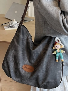 Minimalist grey canvas tote bag with Banatu logo and a cute doll pendant for daily use