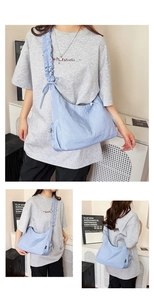 Detailed close-up showing the ruffled shoulder strap and bow of this blue crescent tote