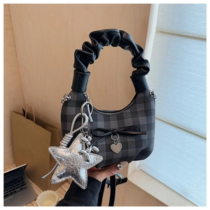 Detail view of checkered moon bag featuring pleated handle and star pendant charm