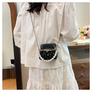 Detail of fashion crossbody bag with silver chain strap and large pearl handle for women