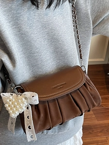 Brown pleated leather crossbody bag with silver chain strap and pearl heart charm accessory
