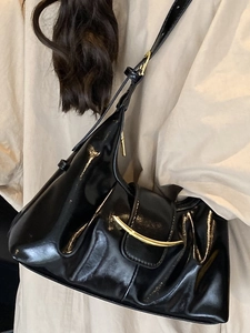 Chic black glossy underarm tote bag for women featuring a stylish gold crescent metal buckle