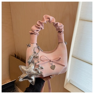 Pink checkered handbag detail showing bow decor, heart pendant and silver star charm