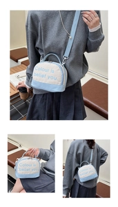 Detail view of the canvas and leather crossbody bag with wide adjustable strap and handles