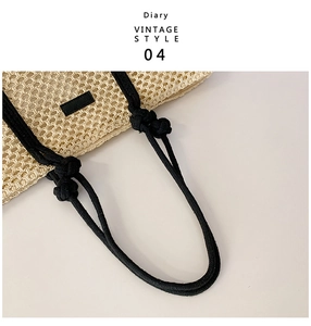 Detail of hollow woven beige tote bag featuring thick black rope handles and leather patch