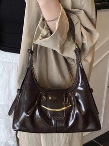 Fashionable dark brown patent leather crescent underarm bag with gold metal hardware