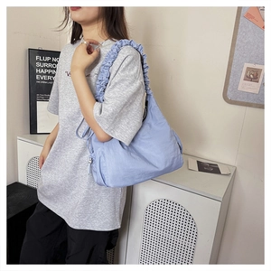 Detail view of large light purple canvas bag with decorative ruffled wide shoulder strap
