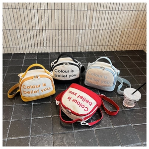 Detailed shot of canvas crossbody bags in four vibrant colors with adjustable straps