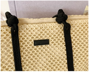Detailed close-up of woven tote bag with beige hollow knit and black rope handles