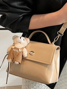 Minimalist beige glossy leather crossbody bag with gold buckle and cute bear charm