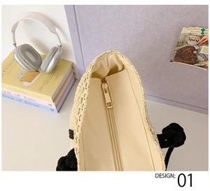 Close-up of beige woven tote bag zipper closure with black rope handle on a desk