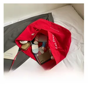Top view of red canvas tote bag showing spacious interior with phone, tablet and cosmetics