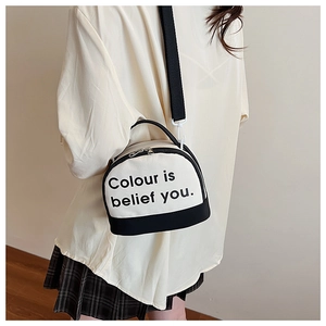 Detail shot of canvas crossbody bag with contrast panel and artistic lettering print
