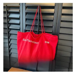 Detail of red oversized nylon tote bag with San Francisco print and long shoulder handles