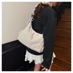 Detail of off-white crescent crossbody bag with adjustable drawstring and nylon texture