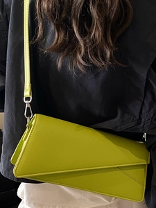 Sac bandoulière asymétrique vert fluo porté avec une tenue décontractée noire