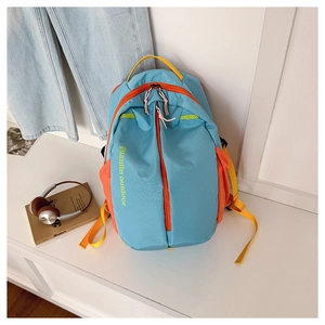 Detail of multi-color outdoor backpack featuring blue nylon and orange side pockets